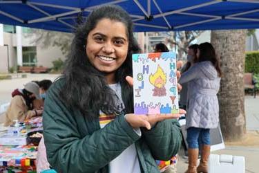 Three students creating art at the ISSS Diwali event during Global Spartan Month